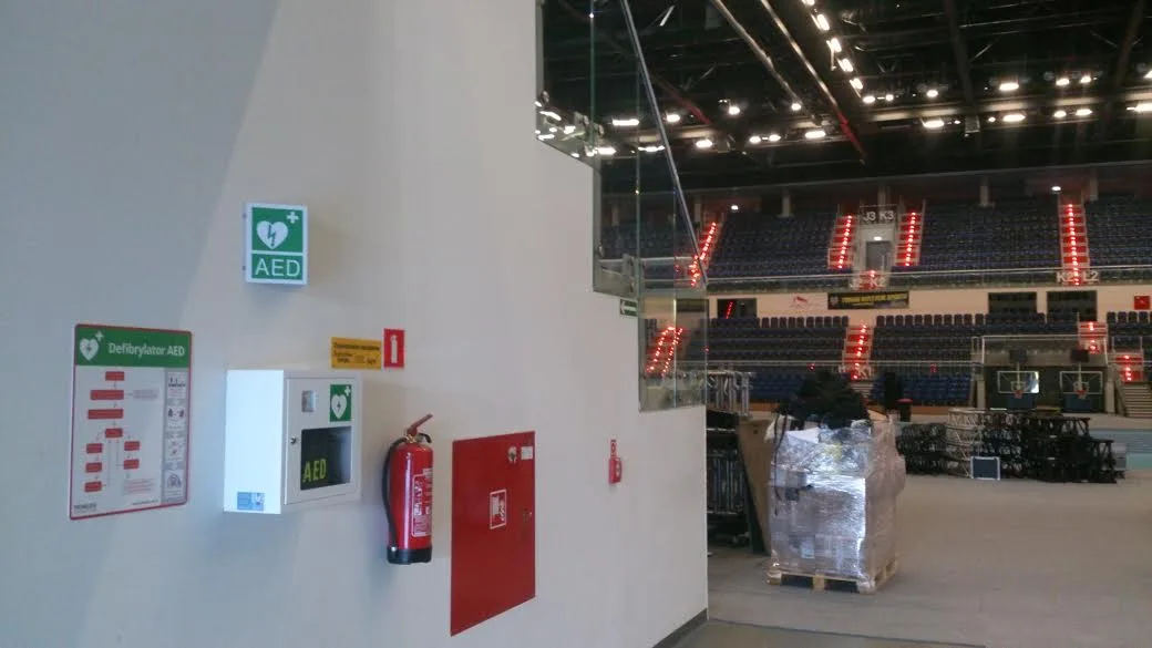Szafka AED z oznakowaniem w hali widowiskowo-sportowej w Toruniu